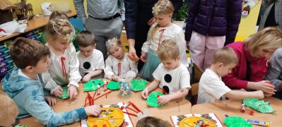 Dzieci wraz z rodzicami wykonują pracę plastyczną 