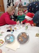 Mama z dzieckiem dekoruje pierniczki