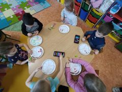 Dzieci tworzą swoją ulubioną pizze z różnych składników.