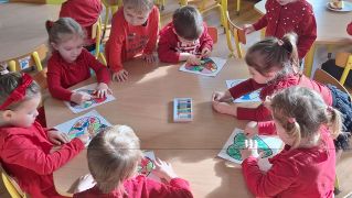 Dzieci przy stole kolorują serduszka