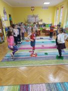 Dzieci podczas zajęć na boso chodzą po puzzlach maty sensorycznej.