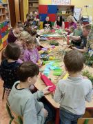 Dzieci z bliskimi tworzą palmy wielkanocne.