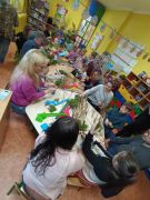 Dzieci z bliskimi tworzą palmy wielkanocne.