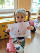 Dziewczynka prezentuje obrazek przedstawiający czosnek