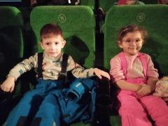 chłopiec i dziewczynka siedzą na fotelach kinowych