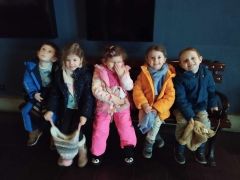 uśmiechnięte dzieci siedzą na sofie