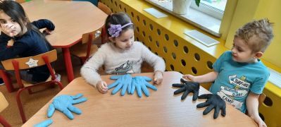 dzieci przy stolikach mają dwie takie same rękawice