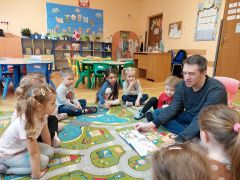 Tata Wojtka czyta dzieciom książkę