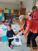 Pani Dyrektor wręcza dziewczynce nagrodę