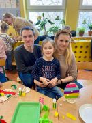 dziewczynka z rodzicami pokazują pisankę