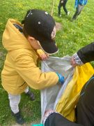 chłopiec wrzuca śmieci do worka