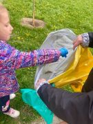 Dziewczynka wrzuca śmieci do worka