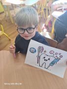 Chłopiec prezentuje pokolorowany obrazek