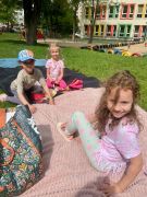 trzy dziewczynki siedzą na kocykach