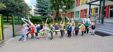 Młodsze dzieci z balonami przed przedszkolem