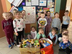 Dzieci pozują do zdjęcia z upominkami.