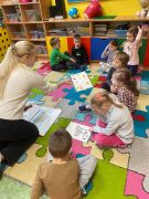 Dzieci wykonują zadanie na dywanie.