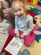 Dzieci wykonują zadanie na dywanie.