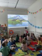 Dzieci oglądają prezentacje o dinozaurach.