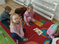 Dzieci układają puzzle na dywanie.