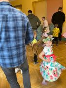 Dzieci tańczą z rodzicami do muzyki.