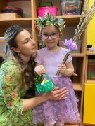 Dziewczynka pozuje z mamą do zdjęcia.