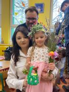 Dziewczynka pozuje z rodzicami do zdjęcia.