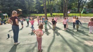 Dzieci ćwiczą na świeżym powietrzu.